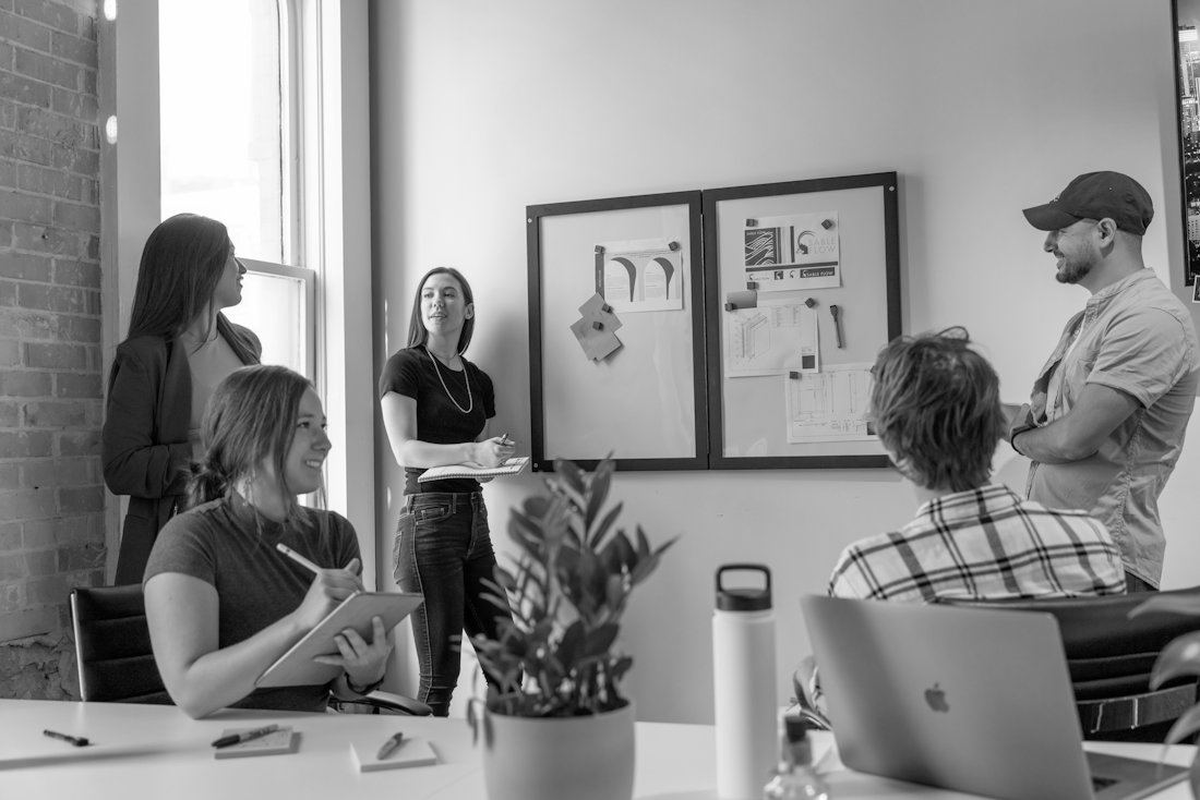 Team discussing work around a table in a bright office