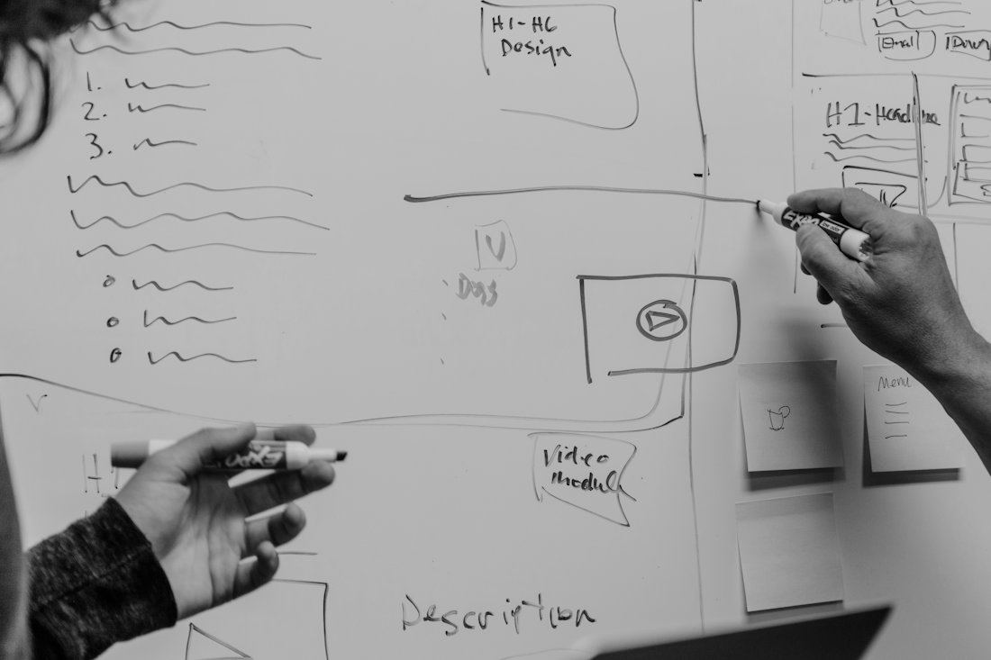 Two people sketching a campaign plan on a whiteboard