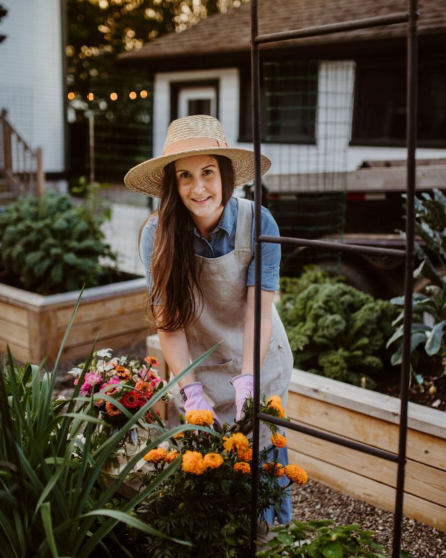 Frau mit Gartenhandschuhen am Hochbeet